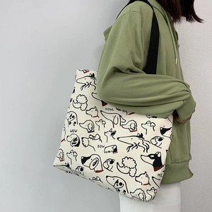 Detail of canvas tote bag showing black dog illustrations and HOWL typography prints