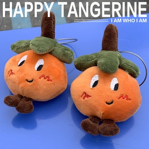 Close-up of tangerine plush pendants with fine embroidery and metal wire loop rings