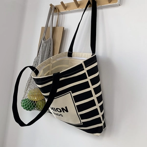 Detail of black and white striped canvas tote with zipper closure and fashion trends print