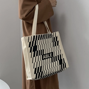 Detail of canvas tote bag featuring geometric patterns and ABLE lettering on fabric