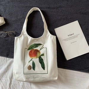 Détail d'un sac cabas en toile blanche avec imprimé pêche réaliste et texte inspirant