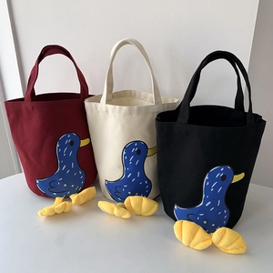 Detailed view of canvas lunch bags in three colors with cute 3D plush duck feet design