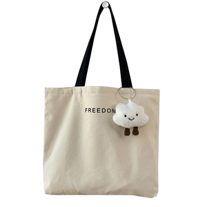 Minimalist beige canvas tote bag with black FREEDOM lettering and cute cloud charm