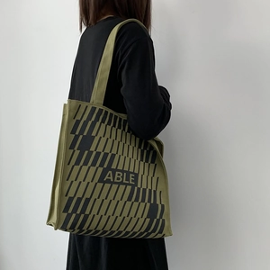 Detail of army green canvas tote bag with black geometric print and ABLE lettering text