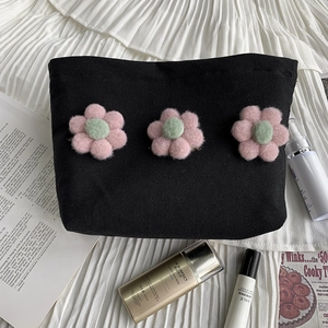 Detailed view of black canvas cosmetic bag with 3D handmade floral embroidery