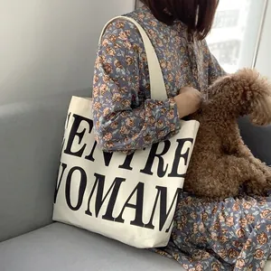 Detail of the large capacity off-white canvas tote bag with black ENTIRE WOMAN print
