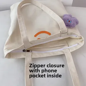 Detail view of canvas tote bag featuring secure zipper closure and internal phone pocket
