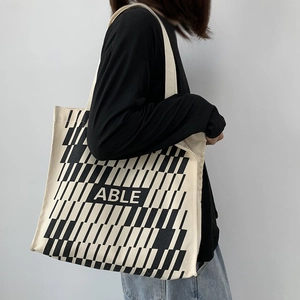 Detail of large canvas tote bag with ABLE lettering and black geometric pattern