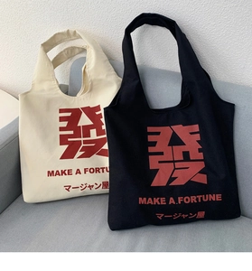 Detail of canvas tote bags with large red character print and MAKE A FORTUNE text