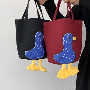 Detail of canvas bento bag featuring 3D plush duck feet and cute polka dot duck pattern
