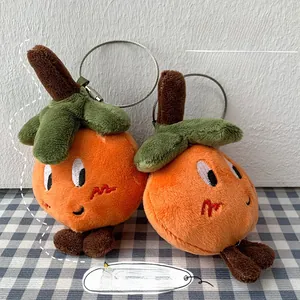 Detail of plush orange and persimmon charms with wire loop on a checkered cloth