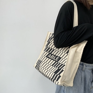 Detailed side view of large canvas tote bag with ABLE print and geometric patterns