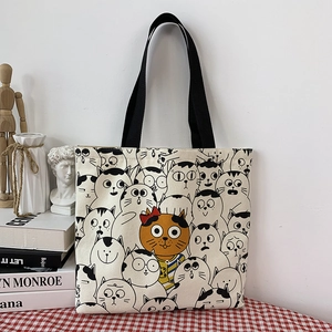 Detail of canvas tote bag with black and white cat prints and an orange cat accent