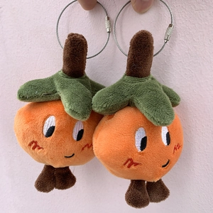 Detail of cute orange plush keychains with cartoon expressions and steel wire ring
