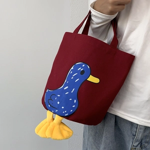 Detail of red canvas lunch bag with cartoon duck print and 3D yellow plush feet