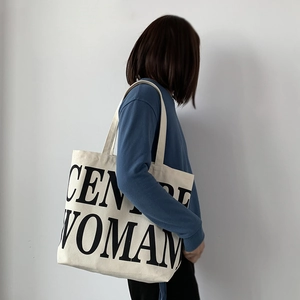 Detailed view of large canvas tote bag with CENTRE WOMAN print shown on a model