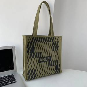 Detail of army green canvas tote bag with black geometric pattern and ABLE logo text