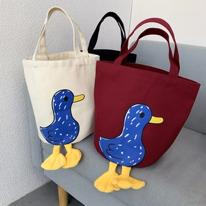 Detailed view of canvas lunch bags with 3D plush duck feet in white, black and burgundy