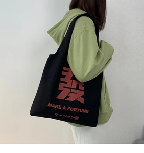 Detail of black canvas tote bag with red Make a Fortune text and creative graphics