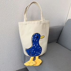Detail of canvas lunch bag featuring cartoon duck print and 3D plush duck feet decor