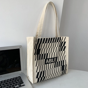 Detail of a large capacity canvas tote bag with geometric pattern and ABLE text