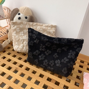 Detailed macro of textured floral jacquard fabric on beige and black cosmetic bags