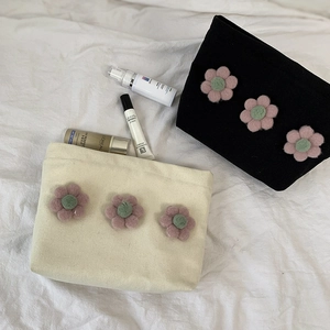 Detail of canvas makeup bags with 3D pink felt flowers and secure zipper closure