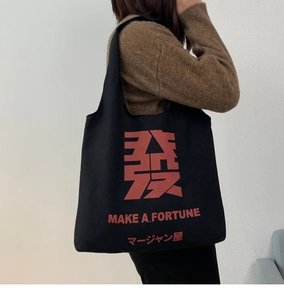 Detail of black canvas tote bag with red Make a Fortune print and Mahjong design