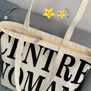 Detail of a high-quality zipper closure on a cream canvas tote with black letter print