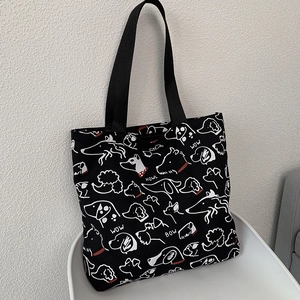 Detail of black canvas tote bag with white minimalist dog prints and large capacity