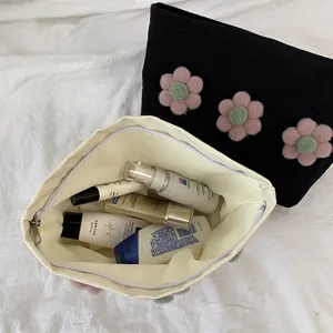 Large floral canvas cosmetic bags in black and cream featuring soft 3D flower accents