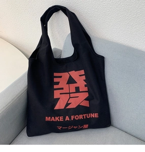 Detail of black canvas tote bag with red Chinese character print and wide shoulder strap