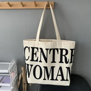Detail of minimalist canvas tote bag featuring large black CENTRE WOMAN text printing