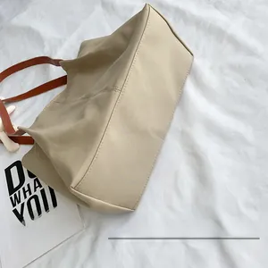 Detail view of the reinforced flat bottom structure on this minimalist beige tote bag