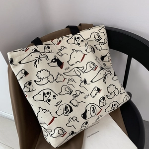 Detail of canvas tote bag featuring hand-drawn dog illustrations and black web handles