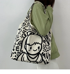 Detail of cream canvas tote bag with black graffiti love print and cartoon art