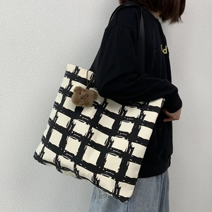 Detail view of large canvas tote bag with black and white grid and cute bear pendant