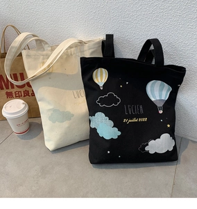 Detail of canvas tote bags with screen-printed Lucien hot air balloon design and handles