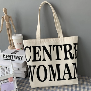 Detail of minimalist canvas tote with 'CENTRE WOMAN' print on textured fabric
