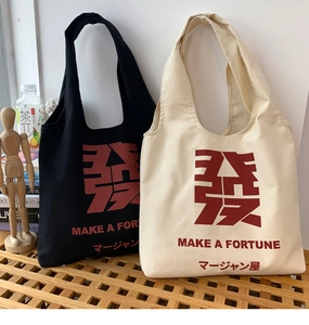 Detail of canvas tote bags with Mahjong theme print on a wooden bench in a lifestyle setting