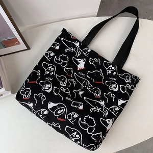 Detail of black canvas tote bag with artistic white dog sketches and woven handles