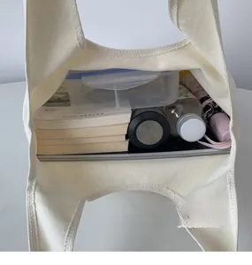 Top view of large capacity canvas tote bag interior showing books, water bottle and umbrella