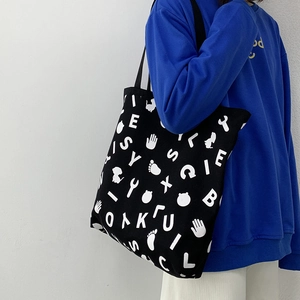 Close-up of durable canvas tote bag with black and white graphic letter prints
