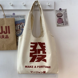 Detail view of durable cream canvas tote bag with red 'Fa' character and bold typography