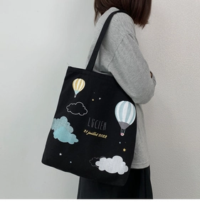 Detail of black canvas tote bag with hot air balloon print and shoulder strap design