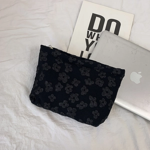 Detailed view of the black jacquard texture and silver zipper on this makeup storage bag
