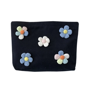 Portable black canvas makeup bag with five colorful 3D floral accents for women