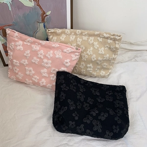 Detailed view of textured floral jacquard fabric on stylish multi-color cosmetic bags