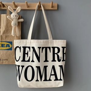 Close-up of durable canvas tote bag featuring bold black CENTRE WOMAN text print