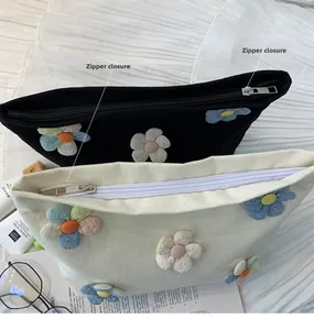 Detail view of canvas makeup bags featuring colorful 3D fabric flowers and zipper closure